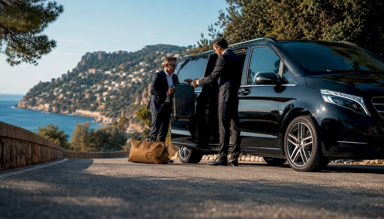 Luxury Mercedes-Benz van with chauffeur assisting corporate passenger near Monaco marina on French Riviera