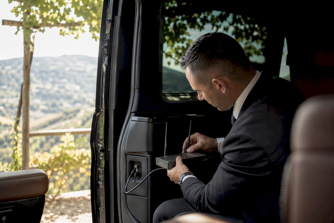 Luxury Mercedes van with chauffeur installing onboard 5G router near Riviera coast