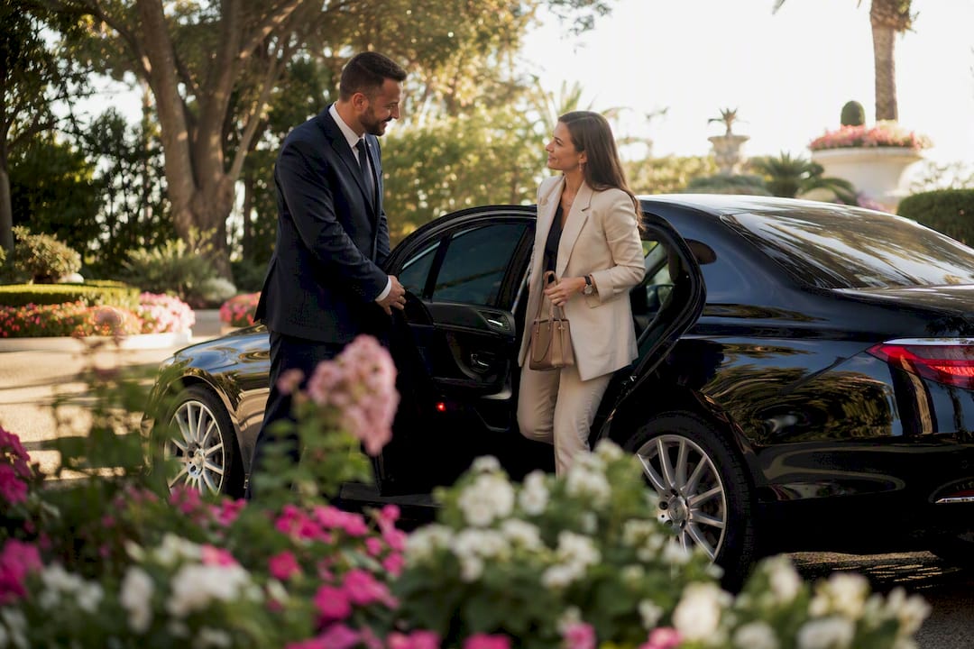 Business sedan concierge door opening outside Nice Airport for elegant Riviera transport