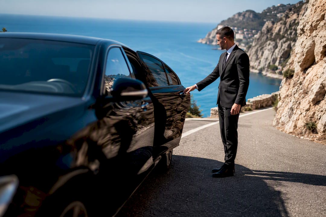 Mercedes-Benz sedan chauffeur opening door along Moyenne Corniche road near Nice
