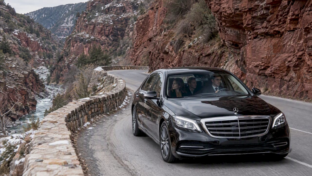 Private chauffeur Mercedes-Benz sedan navigating Valberg road conditions on the D28 Cians gorge route.