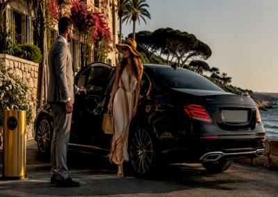Mercedes-Benz sedan with chauffeur assisting passenger on coastal road near Cannes - luxury private transfer Riviera.